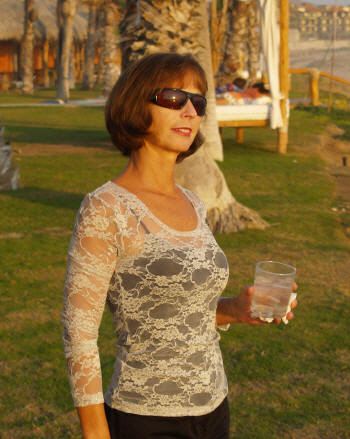 Brigite wearing her Sheer Long Sleeve Lace shirt over a black camisole and sporting our Max Tour Sunglasses in Black